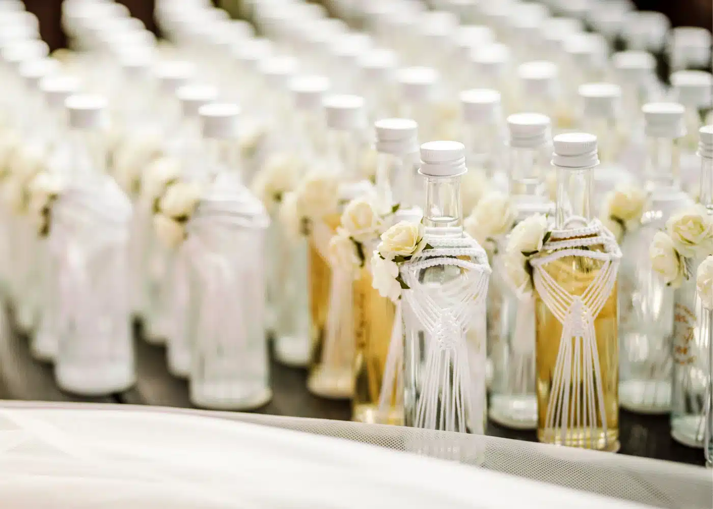 Mini butelki nalewek lub wina z personalizowaną etykietą.